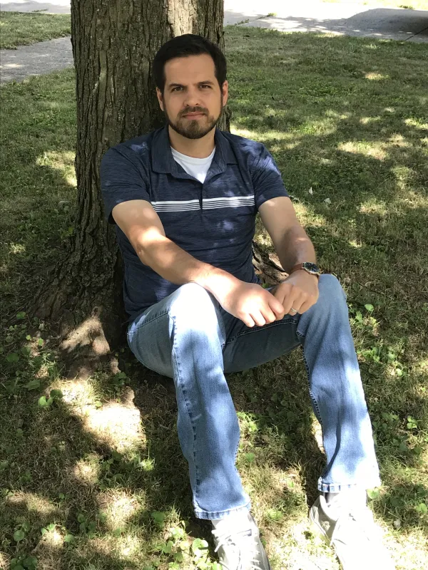 Nathan sitting by a tree